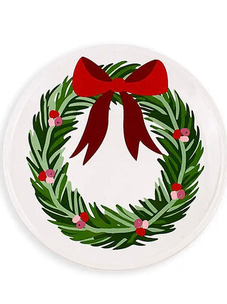 Round white serving platter with green wreath, small pink flowers, and red bow ribbon.