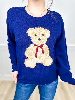 Blue knit sweater with teddy bear intarsia graphic on front, long sleeves