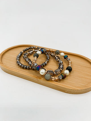Beaded bracelet set with dark gray, gold beads and small pearl accents
