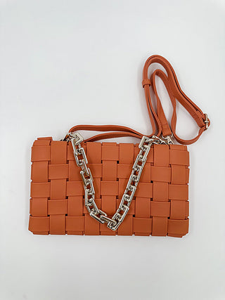 Woven faux leather crossbody bag in orange with long strap and silver chain