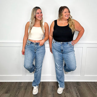 Medium wash high-rise straight-leg jeans with ripped knees and distressed hems