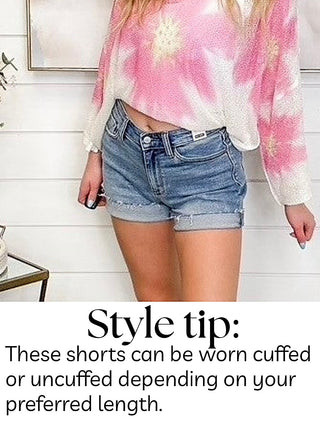 Light wash denim high-rise shorts with raw hem and button closure