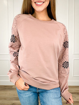 Pink long sleeve top with floral lace sleeves and relaxed fit