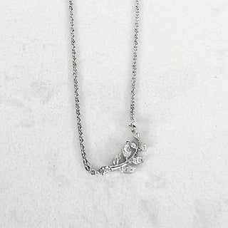 Silver chain necklace with small leaf pendant and dangling charms
