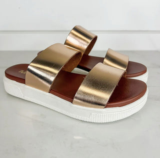 Gold metallic faux leather platform slide sandals with two wide straps and cushioned sole