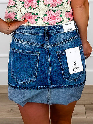 Medium-wash denim cuffed skirt with back pockets and stitched hem cuff