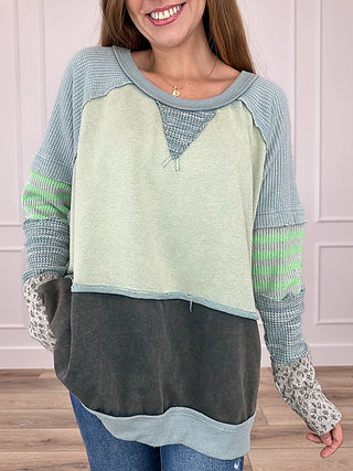 Colorblock long-sleeve raglan top, light green and dark charcoal with blue trim cuffs