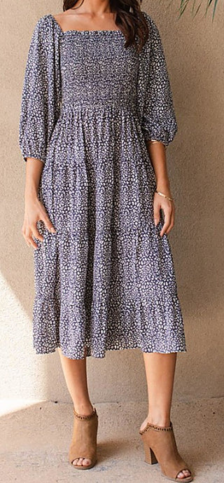 Navy and white printed midi dress with square neckline and puff sleeves, tiered skirt