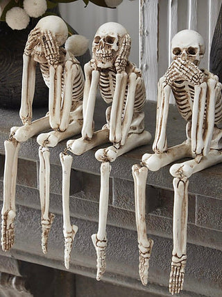 White resin skeleton decor set, four seated standing on ledge with exposed ribs