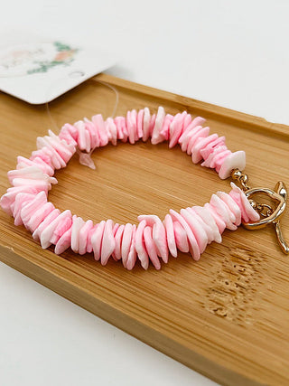 Pink beaded bracelet with gold clasp and heart-shaped charm