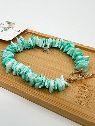 Mint green beaded bracelet with gold clasp and small charm