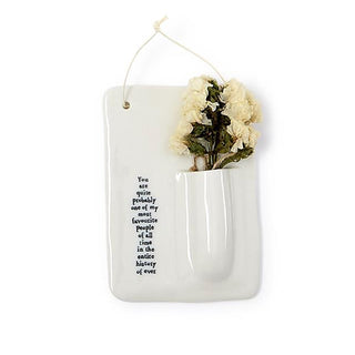 Porcelain hanging bud vase with cream and dark flowers in white pocket