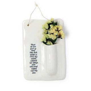 Porcelain hanging bud vase with pale yellow flowers in white pocket