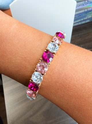 Pink CZ tennis bracelet with alternating clear and fuchsia square stones, on wrist