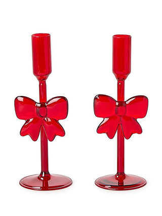 Two red ribbon bow glass candleholders with tall cups and pedestal bases