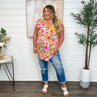 High-rise distressed medium-wash denim capris with front knee tear details