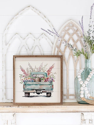 Wood framed hanging sign with floral truck illustration on light background