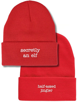 Red knit beanie set: folded cuffs with 'secretly an elf' and 'half-assed jingler'.