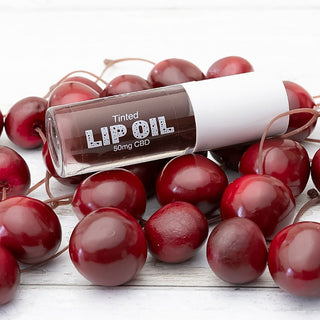 Tinted lip oil bottle in red shade, clear cap, 50mg CBD