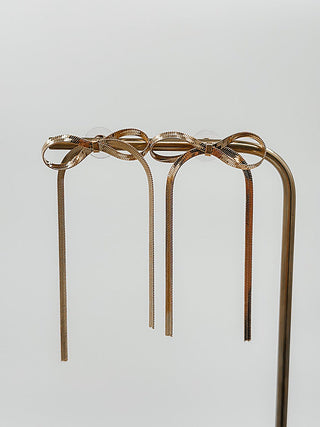 Gold drop earrings with braided ribbon loops and long hanging metal strands