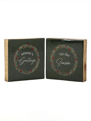 Two-piece wood block sign set on dark-green squares with wreath script: “Season's Greetings” & “’tis the Season”