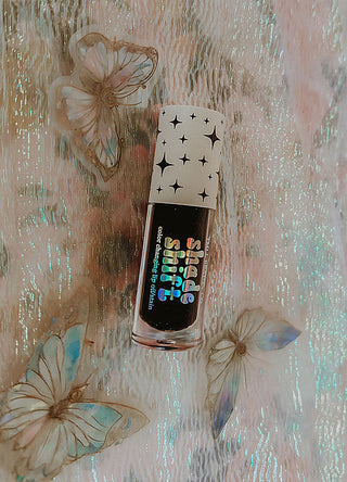 Mood lip oil bottle with dark label and iridescent rainbow lettering