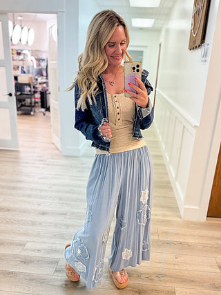 Denim jacket over light blue embroidered dress with clear platform sandals