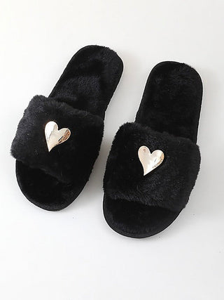 Plush black slide slippers with a gold heart patch on the strap