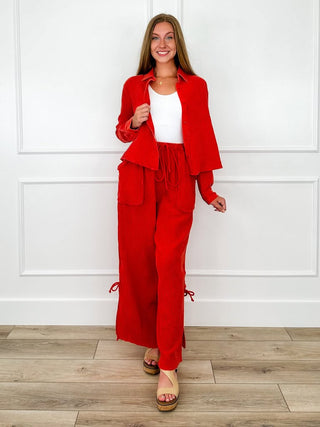 Red button-up crop top and matching high-rise wide leg pants styled with a white tank and tan wedge sandals.