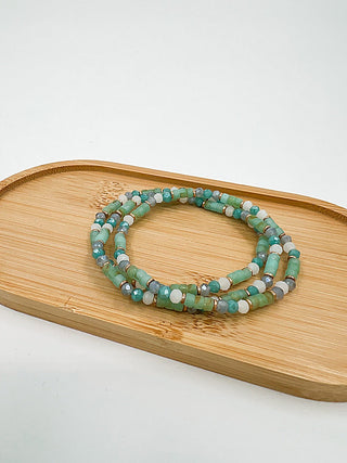 Beaded bracelet set with teal and green beads, stacked in multiple loops