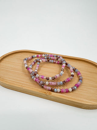 Beaded bracelet set with pink, purple, and gray beads in layered loop style