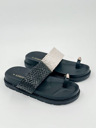 Faux leather slide sandals with black textured strap and metal buckle detail