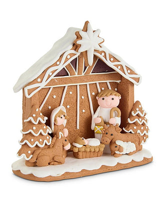 Brown clay nativity house decor with white roof and small figures inside, on base
