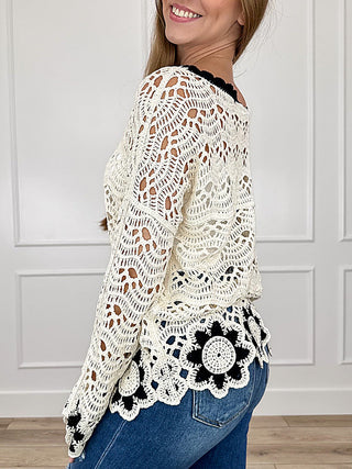 Avery Mae cream knit sweater top, long sleeves, side scalloped hem with black flower motifs