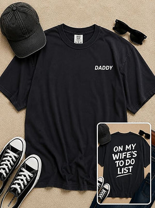 Black short-sleeve cotton graphic T-shirt with white “DADDY” text on the front
