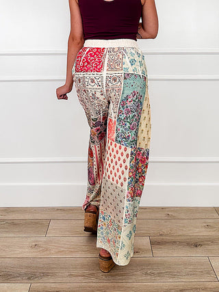 High-rise wide-leg patchwork pants with multicolor medallion pattern, back view.