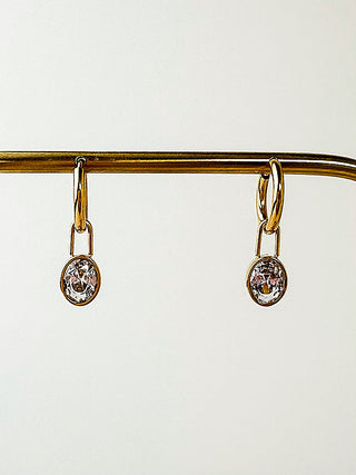 Gold drop earrings with small round crystal charms on lever backs.
