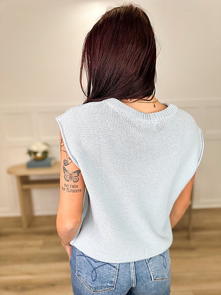 Light blue knit sweater top, back view with cap sleeves and ribbed neckline