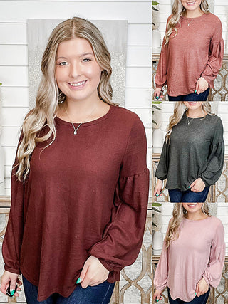 Maroon knit long-sleeve top with round neckline and slightly puffed sleeves