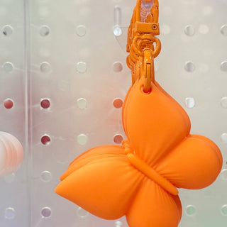 Orange butterfly-style flower lip gloss holder keychain with metal clasp
