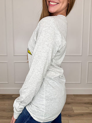 Grey long-sleeve T-shirt, side view, with partial cartoon graphic on chest