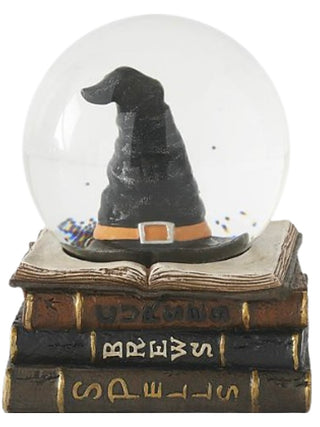 Wicked Cute snow globe with black witch hat on stacked spell books
