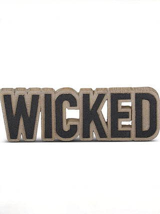 Wood shelf sitter sign reading “WICKED” with dark letters on natural wood backing