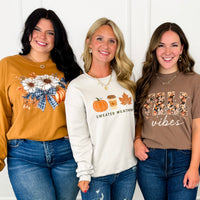 Women wearing Avery Mae Boutique fall graphic tees and sweatshirts in size inclusive regular and curvy sizes: floral pumpkin, Sweater Weather, and Fall Vibes designs with jeans.