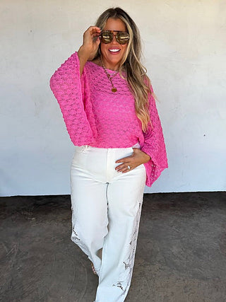 Pink knit long-sleeve cropped sweater with textured pattern and wide neckline